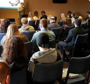 People sitting in a church service looking at pastor speaking