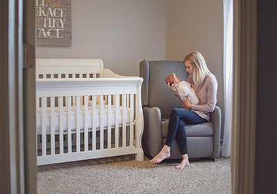Mother holding her baby in a nursery.